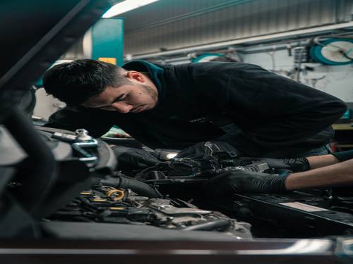 Mécanicien de HORIZON AUTOMOBILES au travail sur un moteur